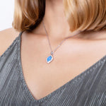 The picture shows a model wearing a 925 sterling silver opalite mandorla pendant with cubic zirconia.