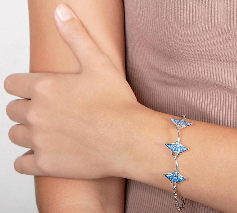 The picture shows a model wearing a 925 sterling silver opalite three manta ray bracelet.