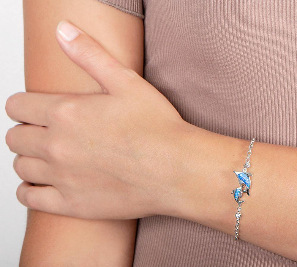 The picture shows a model wearing a 925 sterling silver opalite two dolphin lovers bracelet with cubic zirconia.