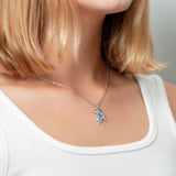 The picture shows a model wearing a 925 sterling silver opalite two dolphin lovers pendant.