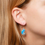 The picture shows a model wearing 925 sterling silver opalite nautilus shell hook earring.