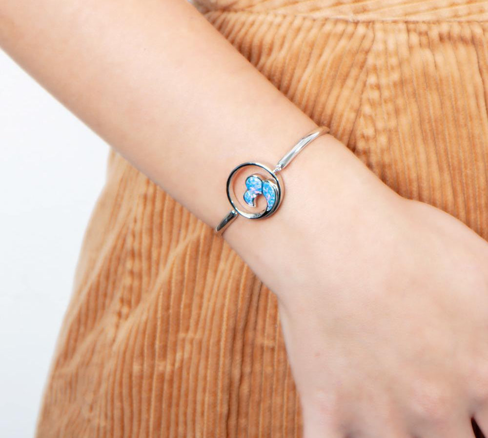 In this photo there is a model wearing a 925 sterling silver big wave bracelet with blue opalite gemstones