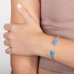 The picture shows a model wearing a 925 sterling silver opalite teardrop bangle.