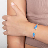 The picture shows a model wearing a 925 sterling silver opalite teardrop bangle.