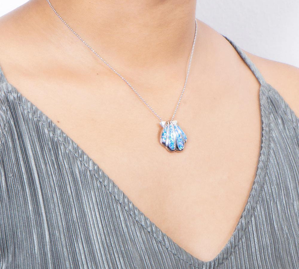 The picture shows a model wearing a 925 sterling silver opalite oyster shell pendant.