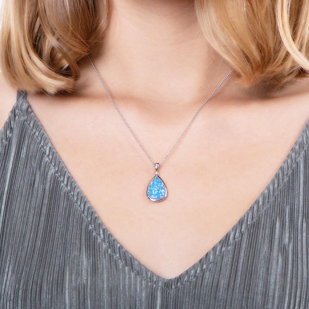 The picture shows a model wearing a 925 sterling silver opalite reuleaux teardrop pendant with cubic zirconia.