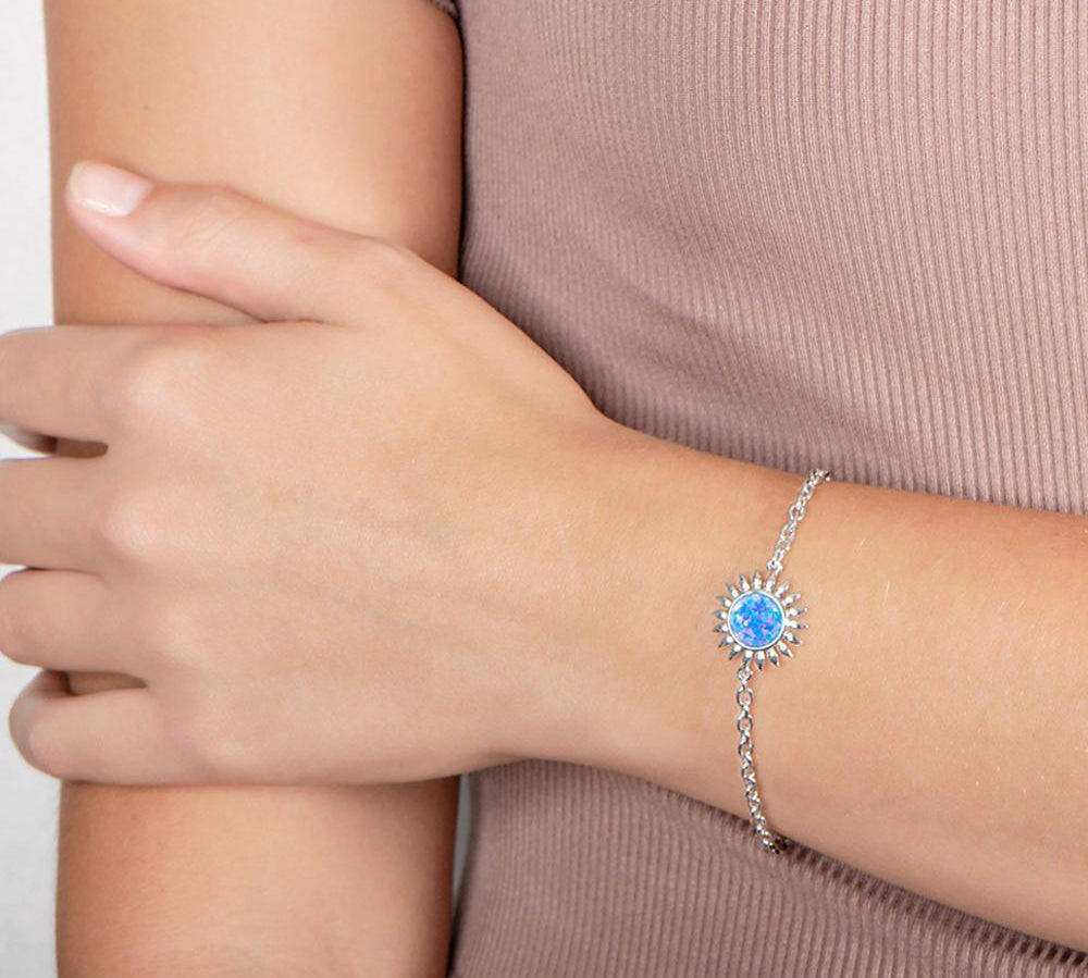 In this photo there is a model wearing a 925 sterling silver sunflower bracelet with one blue opalite gemstone