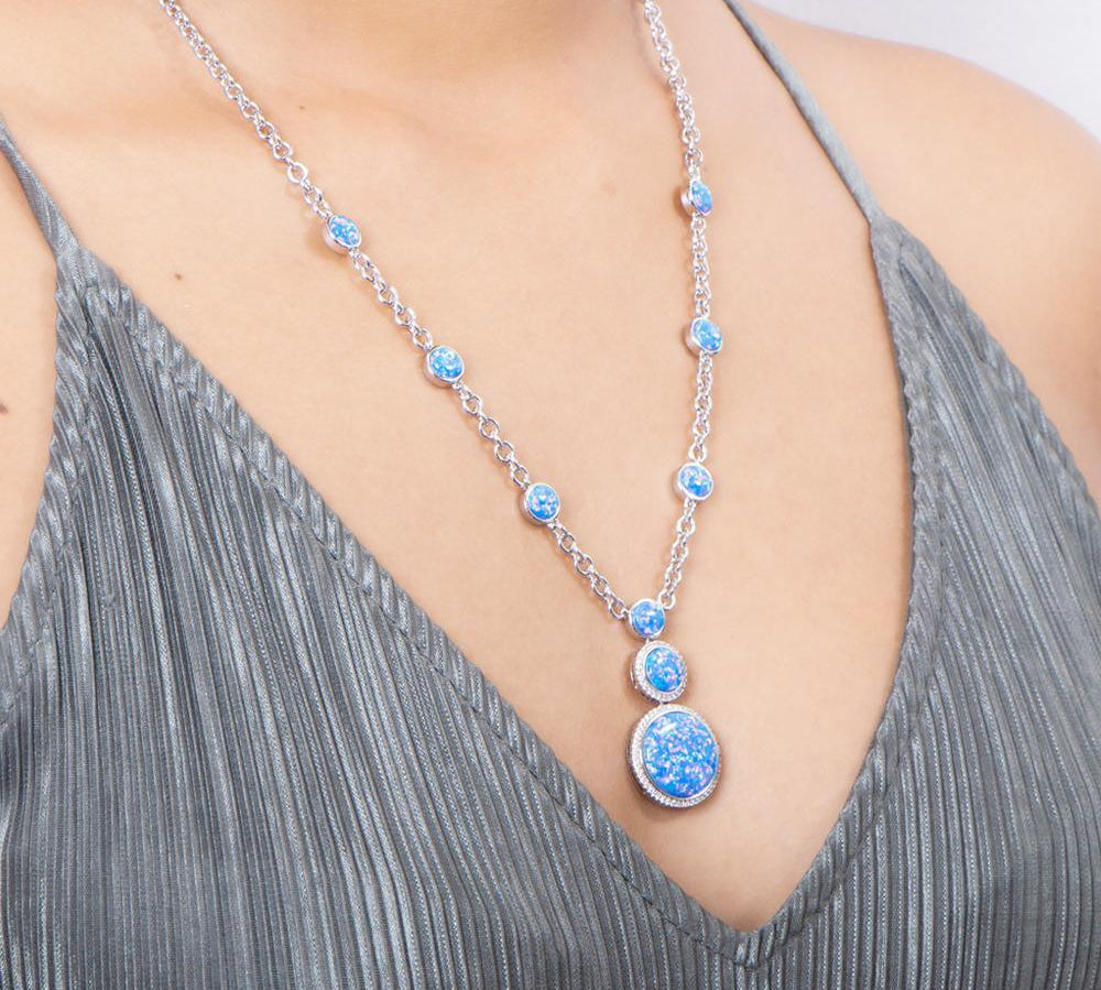 The picture shows a model wearing a 925 sterling silver opalite three circles necklace and topaz.