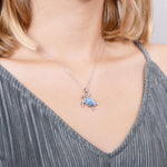 The picture shows a model wearing a 925 sterling silver opalite sea turtle pendant.