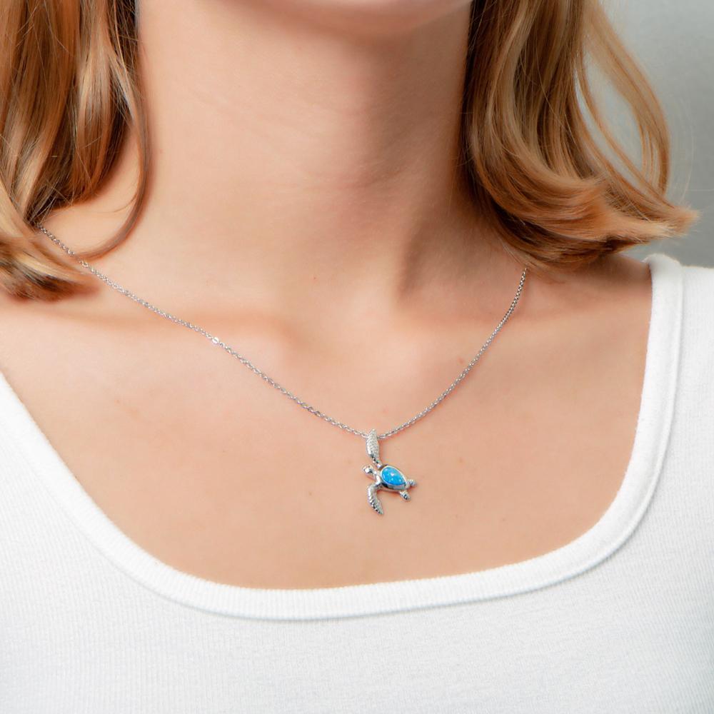 The picture shows a model wearing a 925 sterling silver opalite sea turtle pendant.