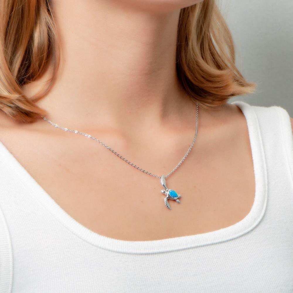 The picture shows a model wearing a 925 sterling silver opalite sea turtle pendant.