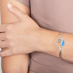 The picture shows a model wearing a 925 sterling silver opalite whale tail wave bracelet.