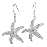 The picture shows a pair of 14K white gold pavé diamond starfish hook earrings.