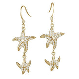 The picture shows a pair of 14K yellow gold pavé diamond starfish hook earrings.