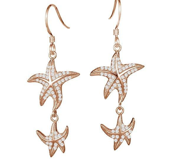 The picture shows a pair of 14K yellow gold pavé diamond starfish hook earrings.