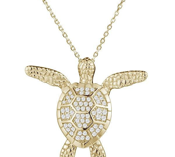 In this photo there is a yellow gold sea turtle pendant with cubic zirconia.