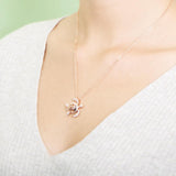 The photo shows a model wearing a rose gold pavé hibiscus adorned sea turtle pendant.