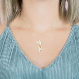The picture shows a model wearing a 925 sterling silver, yellow gold vermeil, hanging double starfish pendant with topaz.