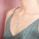 The picture shows a model wearing a 925 sterling silver, white gold vermeil, hanging double starfish pendant with topaz.