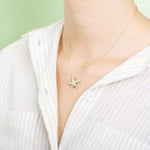 The picture shows a model wearing a 925 sterling silver, yellow gold vermeil, starfish pendant with topaz.