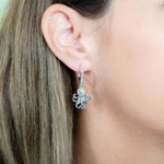 The picture shows a model wearing a 925 sterling silver octopus earring with topaz.
