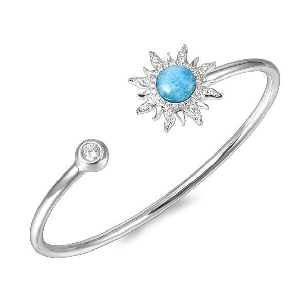 In this photo there is a sterling silver sun bangle with blue larimar, topaz, and aquamarine gemstones.