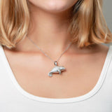 The picture shows a model wearing a 925 sterling silver pavé manatee pendant with cubic zirconia.