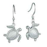 The picture shows a pair of 925 sterling silver white gold-vermeil sea turtle hook earrings with topaz.