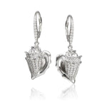 In this photo there is a pair of sterling silver king conch shell earrings with topaz gemstones.