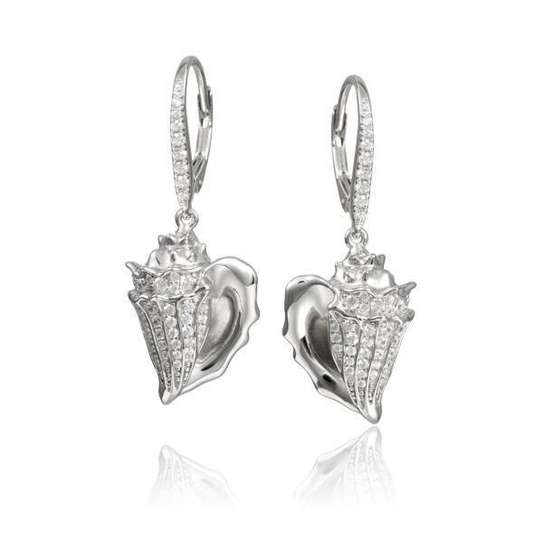 In this photo there is a pair of sterling silver king conch shell earrings with topaz gemstones.