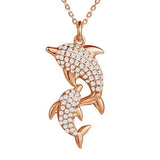 The picture shows a 925 sterling silver, rose gold vermeil, two dolphin pendant with topaz.