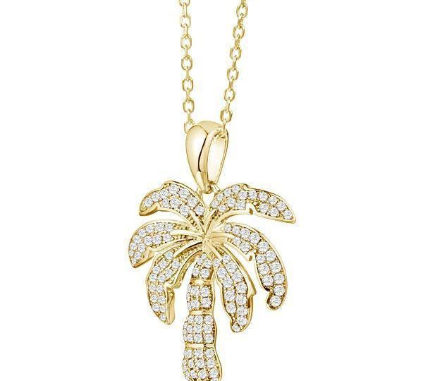 In this photo there is a yellow gold palm tree pendant with topaz gemstones.