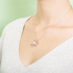 The picture shows a model wearing a 925 sterling silver rose gold vermeil sea turtle pendant with cubic zirconia.