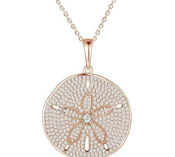 The picture shows a large 925 sterling silver, rose gold vermeil, pavé sand dollar pendant with topaz.