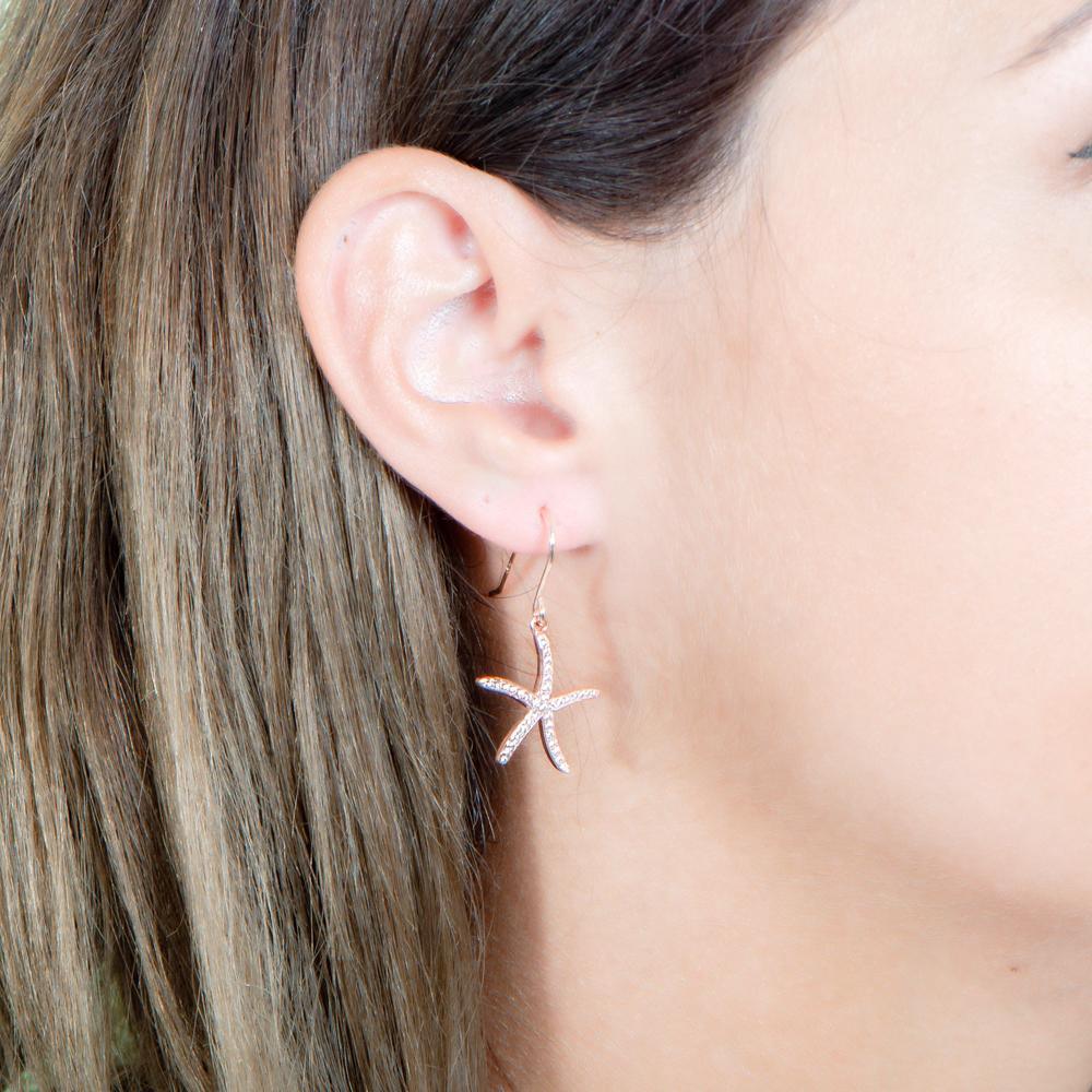 The picture shows a model wearing a 925 sterling silver pavé rose gold vermeil sea star hook earring.