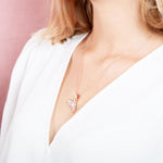 The picture shows a model wearing a 925 sterling silver, rose gold vermeil, pavé whale tail pendant with topaz.