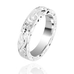 In this picture there is a sterling silver ring with hand engravings including flowers and scrolls.