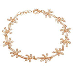 In this photo there is a model wearing a rose gold plated palm tree bracelet with topaz gemstones.