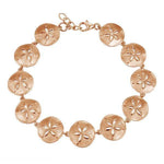 The picture shows a rose gold sand dollar bracelet.
