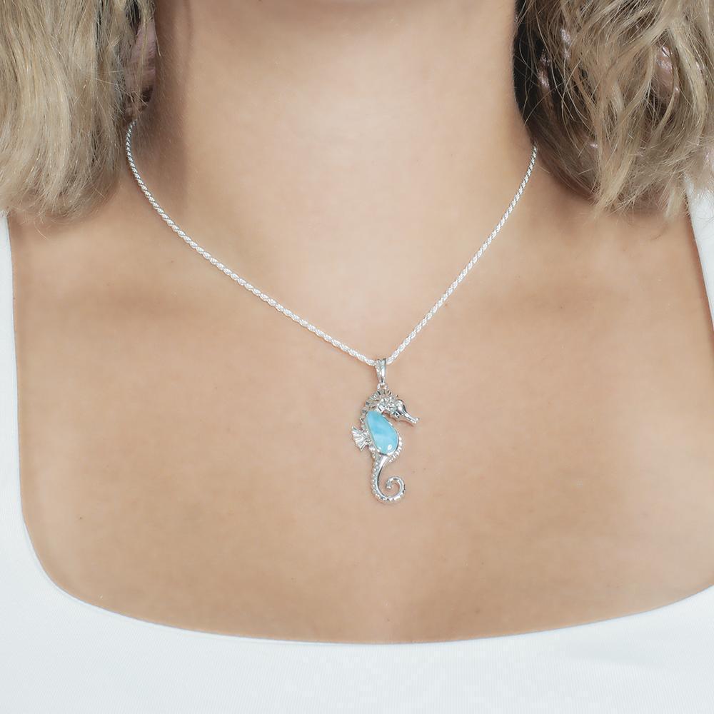 The picture shows a model wearing a 925 sterling silver larimar seahorse pendant.