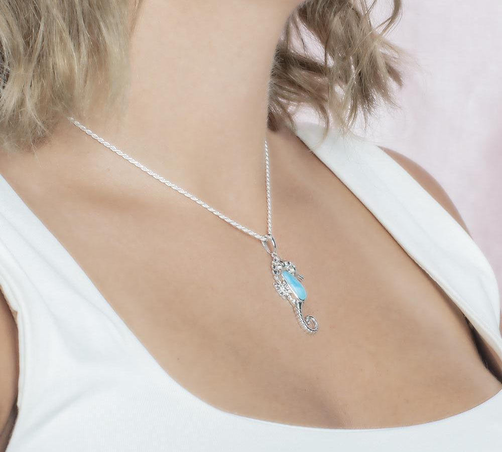 The picture shows a model wearing a 925 sterling silver larimar seahorse pendant.