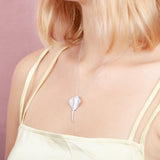  The picture shows a model wearing a white gold manta ray pendant with topaz.