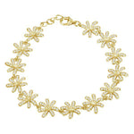 In this photo there is a yellow gold tiare gardenia bracelet with topaz gemstones. 
