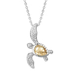 This picture shows a two-tone white and yellow gold sea turtle pendant.
