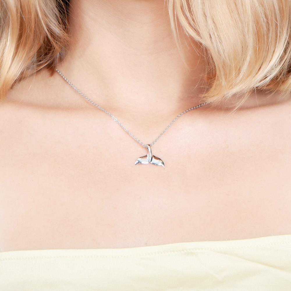 The picture shows a model wearing a 925 sterling silver whale tail pendant.