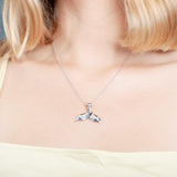 The picture shows a model wearing a 925 sterling silver whale tail pendant.
