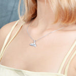 The picture shows a model wearing a 925 sterling silver whale tail pendant.